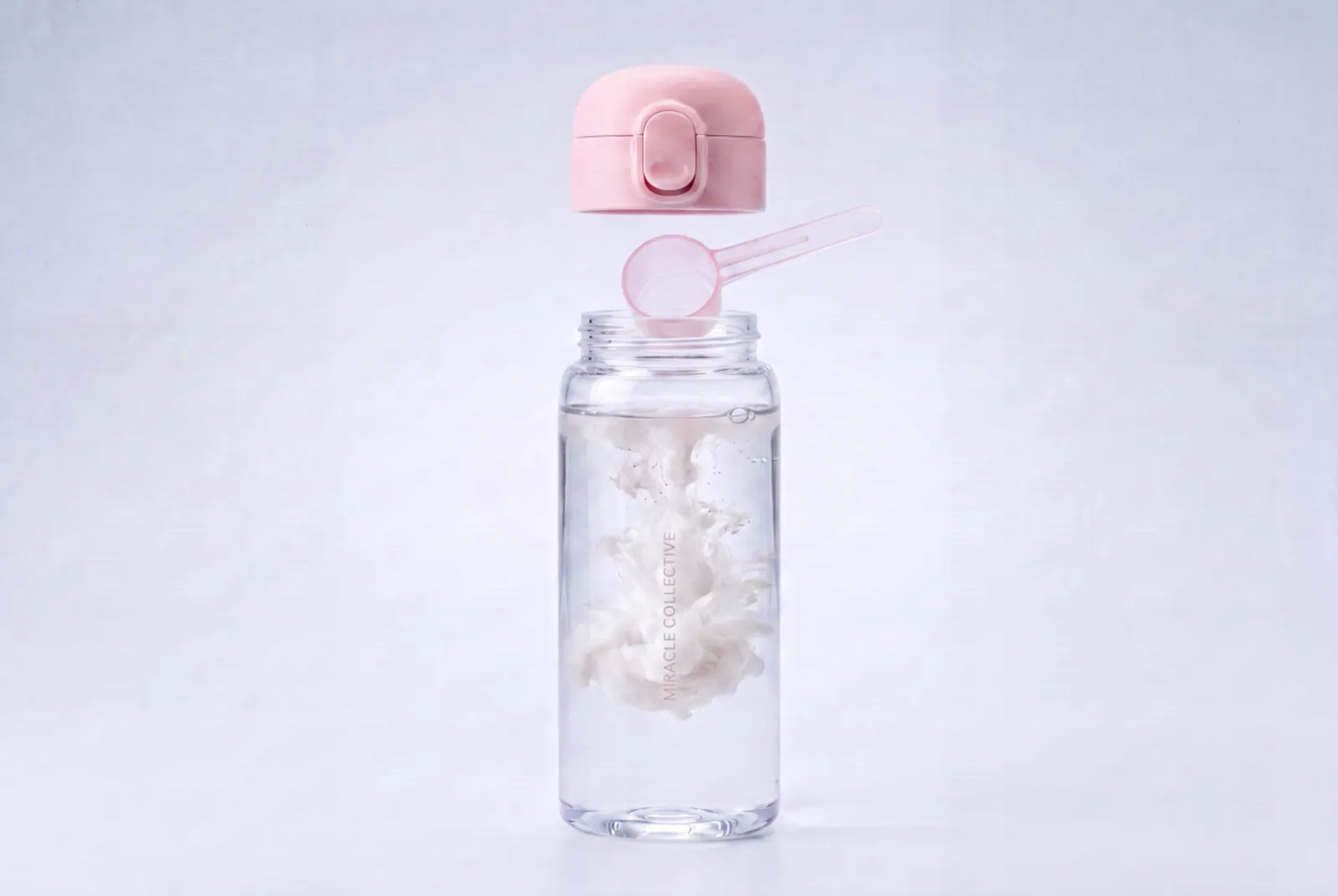 The Miracle Collective bottle — powder blooming through the water